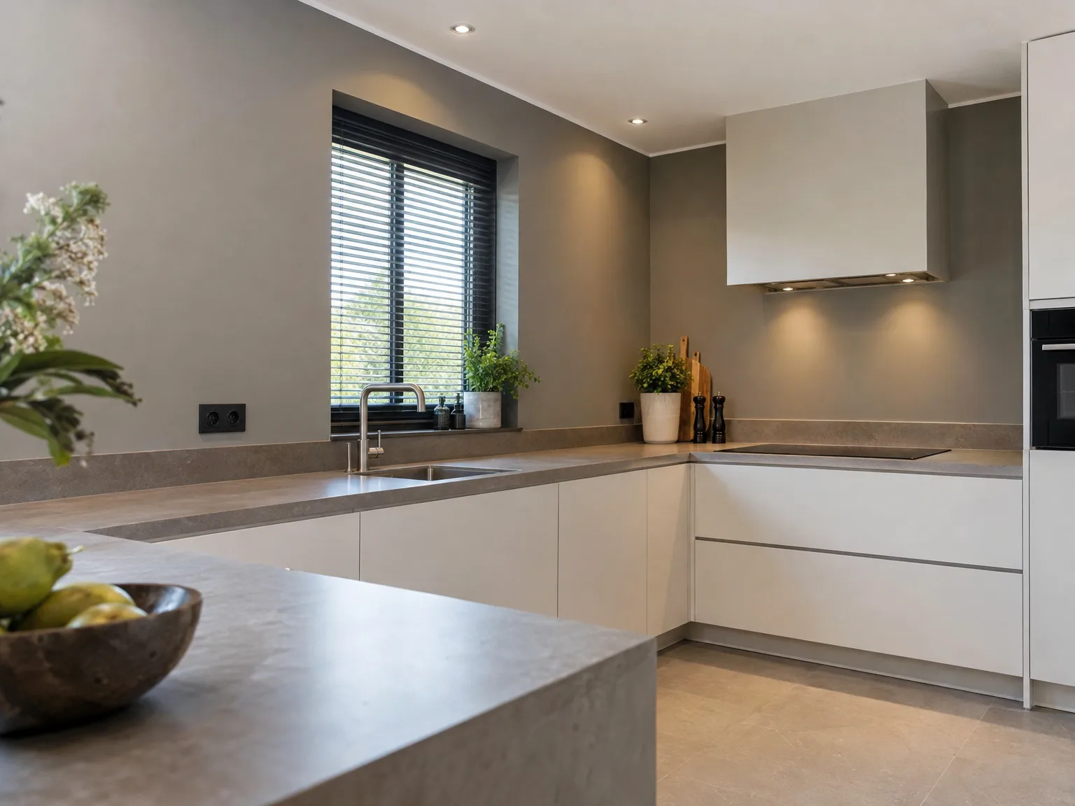 Moderne witte keuken met grijzen werkblad, roestvrijstalen kraan en geïntegreerde inbouwapparatuur